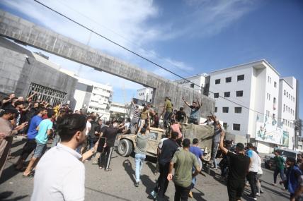На фото: палестинцы берут под свой контроль израильскую военную машину после пересечения пограничного забора с Израилем из Джабалии на севере сектора Газа.