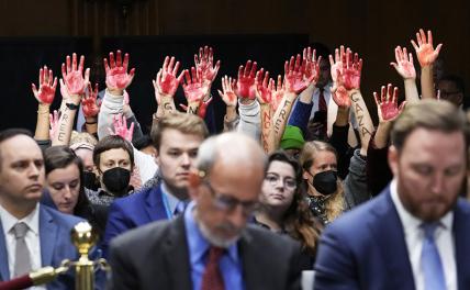 На фото: активисты, выступающие против военных операций Израиля в секторе Газа и их поддержки Вашингтоном, прерывают проходящие в Конгрессе США слушания