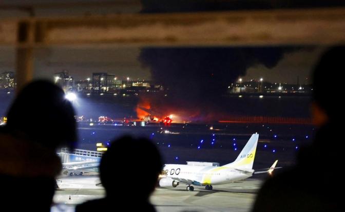 На фото: пассажирский самолет авиакомпании Japan Airlines загорелся на взлетно-посадочной полосе международного аэропорта Ханэда.