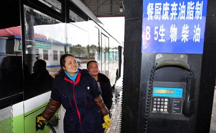 На фото: рабочий заполняет автобус биотопливом, полученным из использованного кухонного кулинарного масла, Шанхай, Восточный Китай