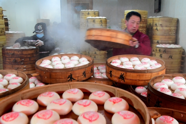 На фото: во время приготовления паровых булочек, чтобы обеспечить поставки на рынок Весеннего фестиваля в Цзиньхуа, провинция Чжэцзян, Китай.