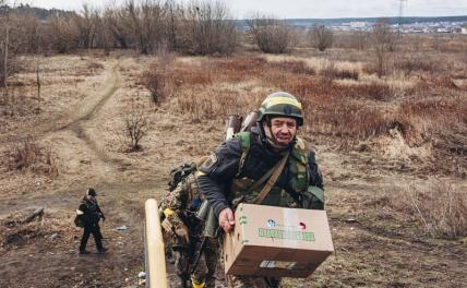 На фото: солдат украинской армии с коробкой с припасами