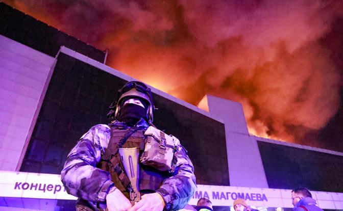 На фото: военный у горящего здания концертного зала "Крокус Сити Холл"