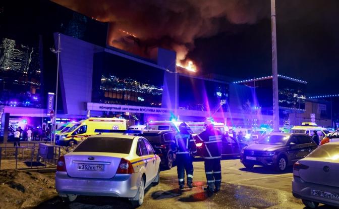 На фото: сотрудники МЧС России и пожарной охраны у горящего здания концертного зала "Крокус Сити Холл". Неизвестные устроили стрельбу в "Крокус Сити Холле", идет эвакуация людей.