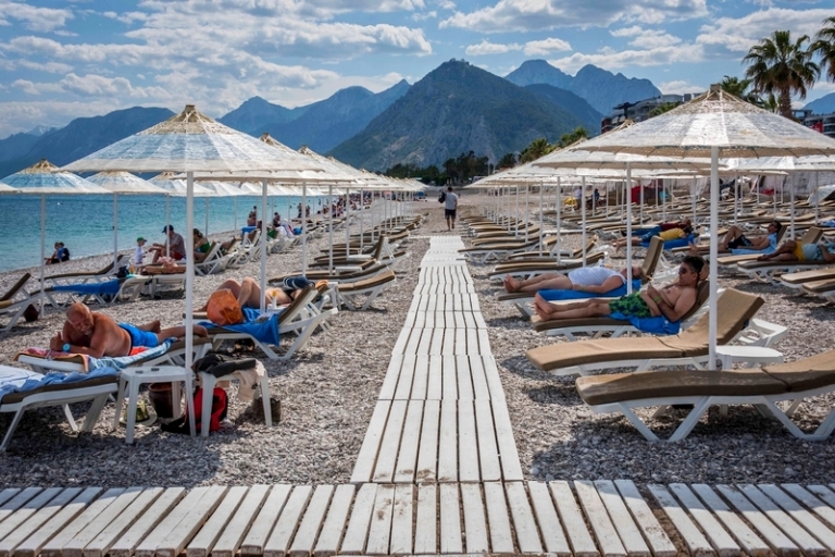 На фото: На фото: туристы на пляжах Антальи, туристического центра на южном побережье Турции.