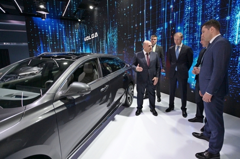 На фото: первый вице-премьер РФ Денис Мантуров (третий слева) и премьер-министр РФ Михаил Мишустин (слева) у автомобиля Volga C40 на выставке IX конференции "Цифровая индустрия промышленной России".