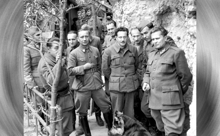 На фото: маршал Иосип Броз Тито (крайний справа) со своим кабинетом министров и главными офицерами штаба в Дрваре, за несколько дней до наступления, 1944 год. На переднем плане также можно увидеть собаку Тито, Тигра.