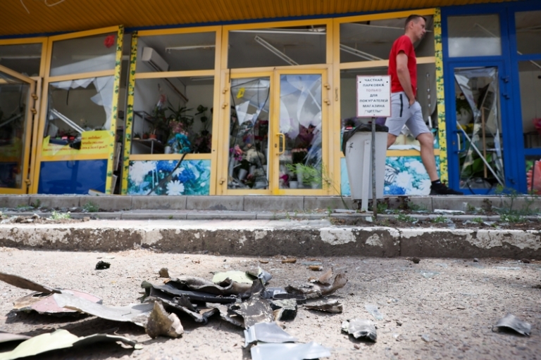 На фото: мужчина у магазинов, поврежденных в результате обстрела Луганска со стороны ВСУ. 