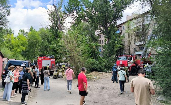 На фото: люди у жилого дома, поврежденного в результате обстрела Луганска, Россия, со стороны ВСУ.