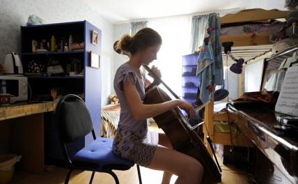 На фото: студентка Московской государственной консерватории имени П.И. Чайковского во время подготовки к занятию в комнате общежития.