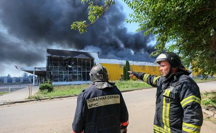 На фото: сотрудники МЧС у сгоревшего торгового центра "Галактика" после обстрела со стороны ВСУ в Петровском районе.