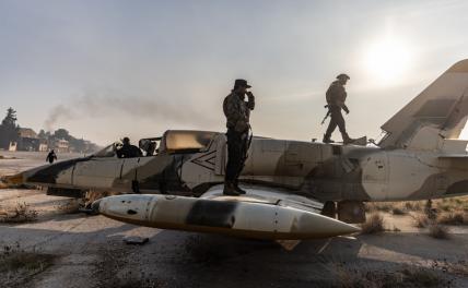 На фото: члены сирийской вооруженной оппозиции на борту военного самолета после взятия под контроль военного аэропорта Найраб в городе Алеппо, Сирия.