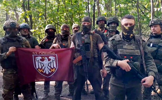 На фото: бойцы РФ показали захваченный флаг элитной 82-й бригады ВСУ.