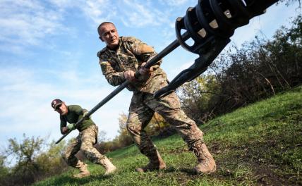 На фото: украинские военнослужащие прочищают дуло украинской гаубицы Д-30.