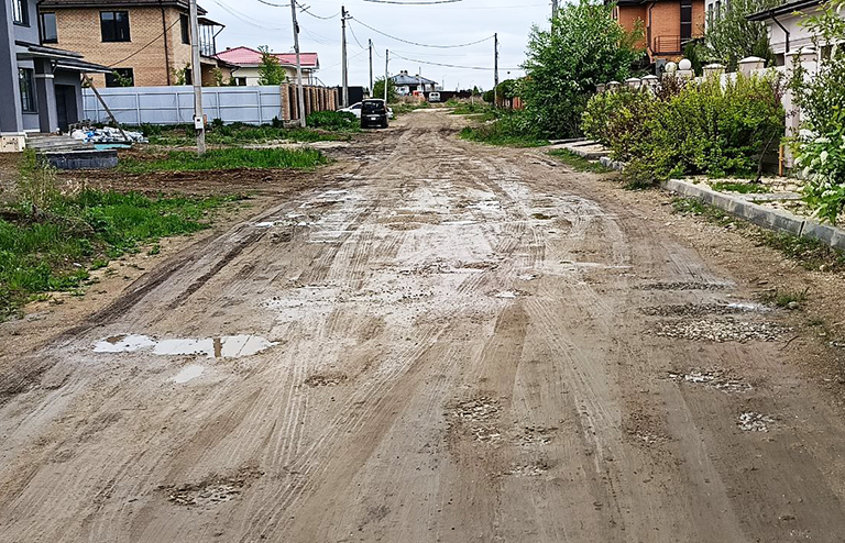 Грязь на дороге в пригородном поселке Западный после коммунальной аварии