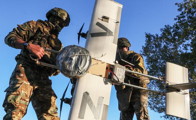 На фото: военнослужащий расчета ударного БПЛА "Молния-2" ударно-разведывательной батареи 18-й общевойсковой армии в составе группировки войск "Днепр" во время оснащения БПЛА "Молния-2" противотанковой миной в качестве боевого заряда в зоне СВО.