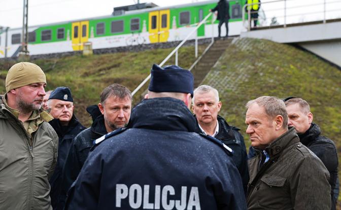 На фото: премьер-министр Польши Дональд Туск (второй справа) на месте повреждения путей на железной дороге.