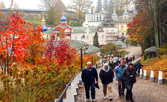 На фото: люди на фоне Свято-Успенского Псково-Печерского монастыря, Печоры, Псковская область.