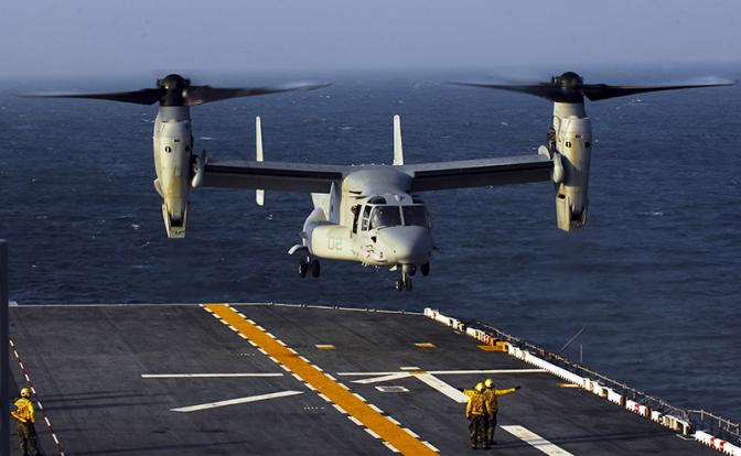 На фото: военно-транспортный самолет с поворотными двигателями V-22 Osprey готовится к посадке на борт USS Bataan в Атлантическом океане.