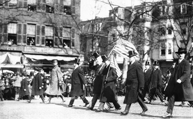 На фото: президент США Вудро Вильсон несет флаг (приподнимает цилиндр) на параде в честь победы в Первой мировой войне, Нью-Йорк, 1919 год.