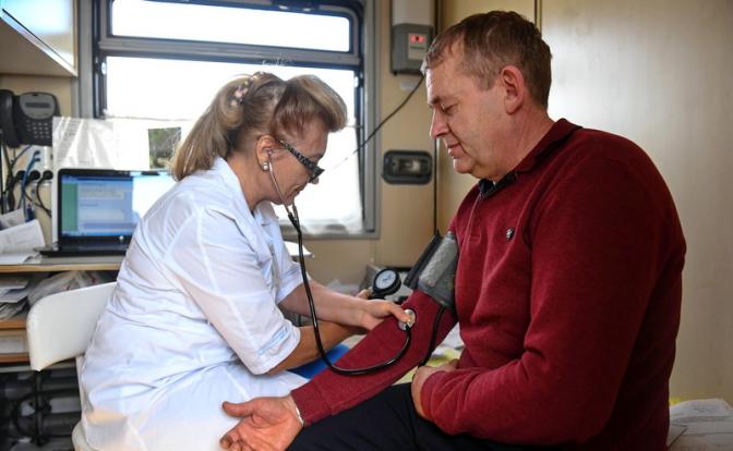 На фото: врач-терапевт измеряет артериальное давление.