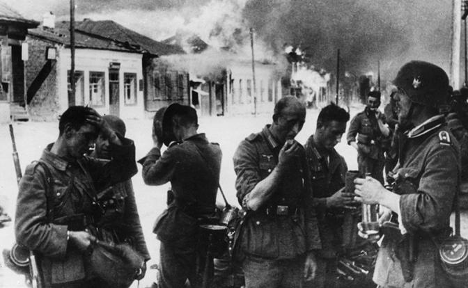 На фото: Великая Отечественная война. Немецкие солдаты в Витебске рядом с горящими домами, СССР, июль 1941 года