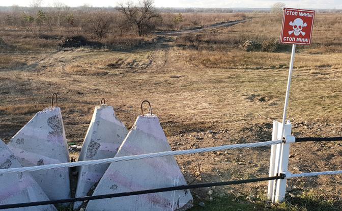 На фото: красный щит предупреждает об опасности мин в демилитаризованной зоне.