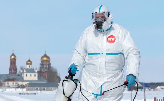 на фото: Новосибирская область. Дезинфектор на пропускном пункте на въезде в село Козиха Ордынского района