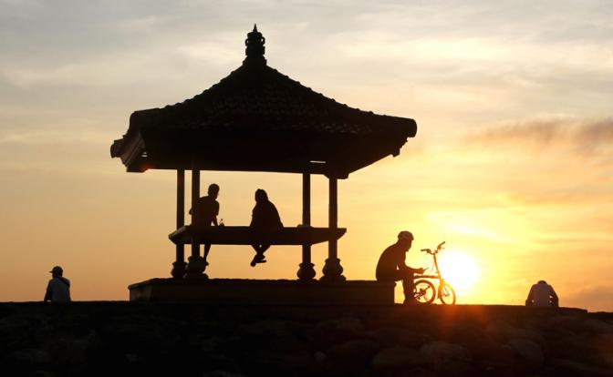 На фото: туристы в кафе на берегу океана в городе Денпасар, остров Бали, Индонезия.