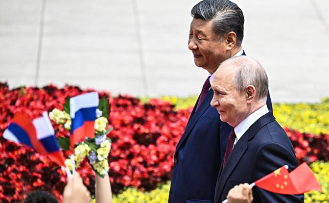 На фото: президент РФ Владимир Путин и председатель Китайской Народной Республики Си Цзиньпин (справа налево) во время торжественной церемонии встречи на площади Тяньаньмэнь.