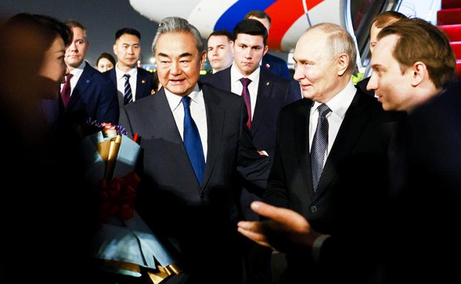 На фото: президент РФ Владимир Путин и министр иностранных дел Китая Ван И (в центре справа налево) во время торжественной церемонии встречи в международном аэропорту Шоуду.