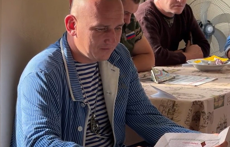 На фото: солдат читает письмо от школьников