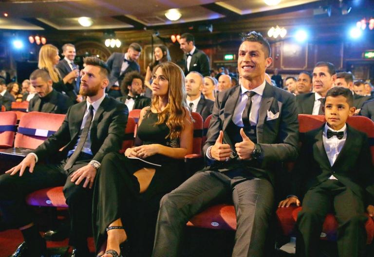 На фото: португальский футболист Криштиану Роналду (второй справа) и его сын Криштиану Роналду-младший (справа) сидят рядом с аргентинским футболистом Лионелем Месси (слева) и его женой Антонеллой во время церемонии вручения наград The Best FIFA 2017 Awards в театре «Палладиум» в Лондоне, Великобритания, 2017 год.