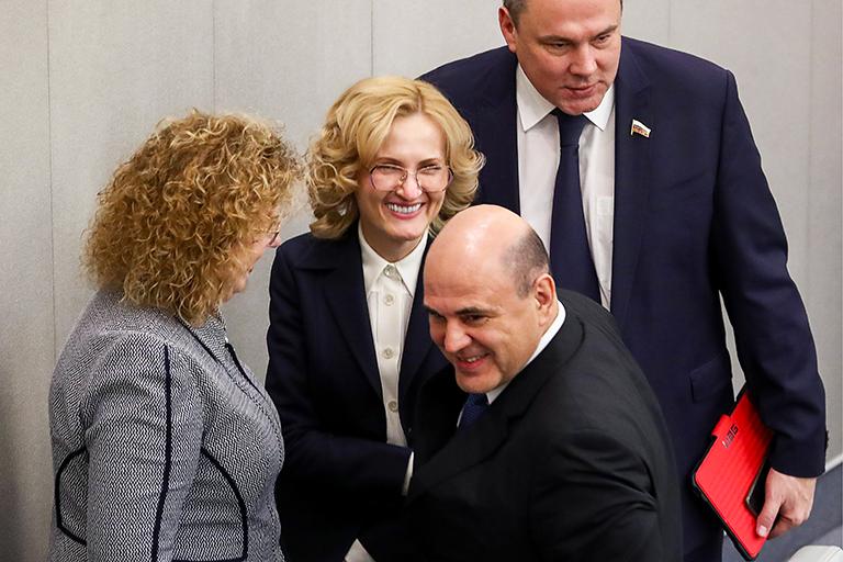 На фото: согласованный Госдумой РФ на должность премьер-министра РФ Михаил Мишустин (на первом плане) и вице-спикеры Госдумы РФ Ольга Епифанова, Ирина Яровая и Петр Толстой (слева направо на втором плане) после пленарного заседания Государственной думы РФ. 15 января 2020 года президент РФ Владимир Путин предложил кандидатуру руководителя Федеральной налоговой службы Михаила Мишустина на должность премьер-министра России. 16 января 2020 года