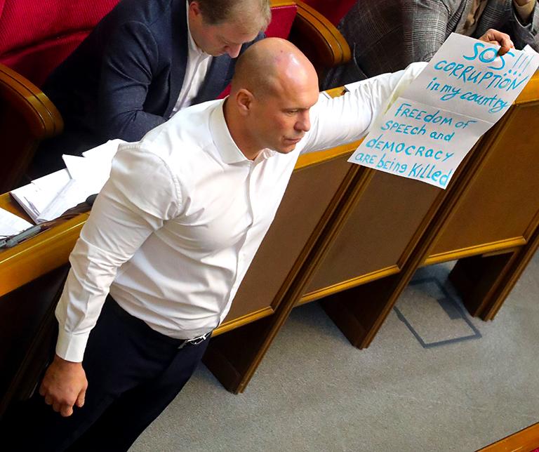 На фото: народный депутат Илья Кива держит плакат с обращением к Генеральному секретарю НАТО Йенсу Столтенбергу во время парламентского заседания в Верховной Раде Украины, Киев, столица Украины, 31 октября 2019 года