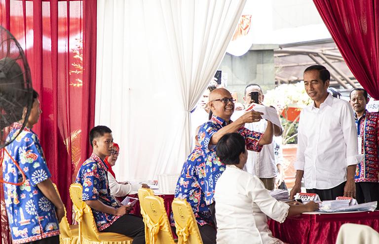 На фото: администратор избирательного участка показал бюллетень для голосования кандидату в президенты Индонезии Джоко Видодо на избирательном участке