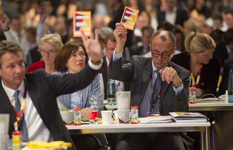 На фото: Фридрих МЕРЦ, кандидат на пост председателя КПУ, и его жена Шарлотта присутствуют на пленарном заседании, голосуют карточками для голосования на 31-й партийной конференции ХДС 2018 в Гамбурге, 2018