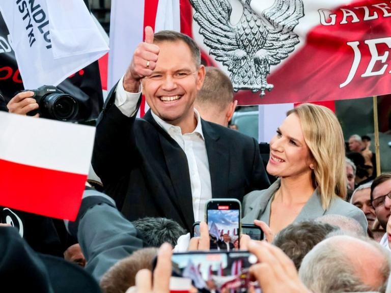 На фото: кандидат в президенты Кароль Навроцкий, поддерживаемый правой партией &laquo;Право и справедливость&raquo;, и его жена Марта на предвыборном митинге перед вторым туром выборов. Первый тур не определил, кто станет президентом страны, поскольку ни один кандидат не набрал 50% голосов. Два победивших кандидата &mdash; Рафал Тшасковский и Кароль Навроцкий &mdash; прошли во второй тур.