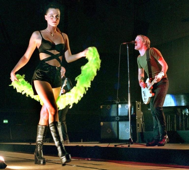 На фото: канадская рок-звезда Брайан Адамс выступает на сцене вместе с молодой девушкой во время своего немецкого турне в Ганновере, 1997 год.