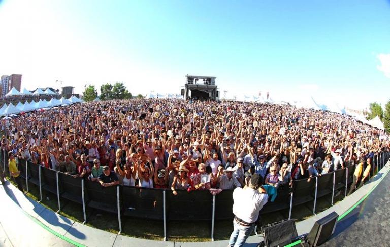 На фото: тысячи людей собрались в Форт-Калгари, чтобы посмотреть выступление Dudes, The Doobie Brothers и хедлайнера Брайана Адамса на фестивале Stampede Roundup в Форт-Калгари в Калгари, Альберта, 2014 года. В 2013 году Stampede Roundup собрал 225 000 долларов для Ротари-клуба Калгари в поддержку проекта Pathways и Фонда помощи пострадавшим от наводнений Rotary.