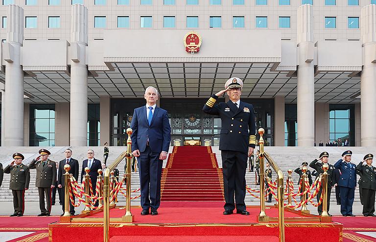 На фото: министр обороны РФ Андрей Белоусов и министр обороны Китая адмирал Дун Цзюнь (слева направо на первом плане) у здания Центрального военного совета КНР во время церемония официальной встречи российской делегации с участием роты почетного караула и оркестра, 2024