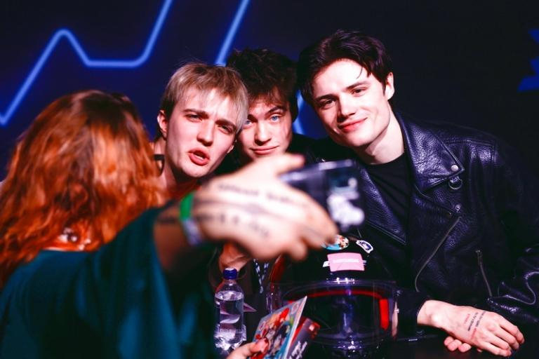 На фото: актеры Иван Трушин, Максим Сапрыкин и Даниэль Вегас (слева направо) фотографируются с поклонницей на презентации фильма "Твое сердце будет разбито" во время фестиваля поп-культуры "Фандом фест Вконтакте" на площадке Main Stage, Москва, 2025 год.