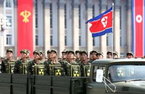 На фото: северокорейские солдаты смотрят на лидера Ким Чен Ына, держа в руках рюкзаки с ядерным символом во время парада, посвященного 60-летию перемирия в Корейской войне, в Пхеньяне, Северная Корея.